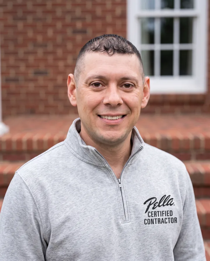 Concept image: Jesse Monroy, owner of Platinum Experts, in a Pella Certified Contractor quarter-zip in front of a brick home